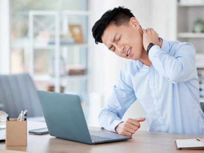 Business, man and neck pain from injury in office with muscle tension, bad posture and fatigue at desk. Professional, asian employee or stress for inflammation, mental health and strain with laptop.